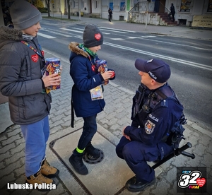 Policjant kuca, dziecko nakleja mu serduszko