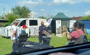 Ludzie przy stoisku policyjnym rozmawiają z policjantami i oglądają wyposażenie