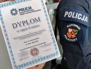 Dyplom i ręka z naszywka policyjny ratownik