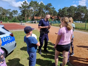 Młodzież przy policjancie na boisku