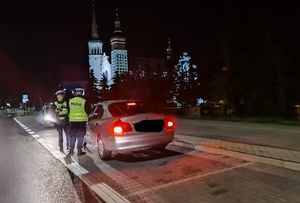 Policjanci przy drodze w nocy kontroluja pojazdy