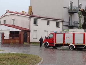 Policjant przy wozie strażackim