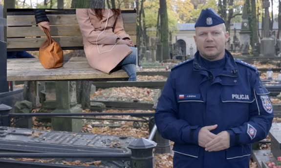 Policjant mówiący na cmentarzu