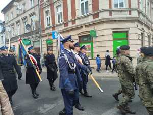 Policjanci w przemarszu, komendanci, poczet flagowy oraz pomnik