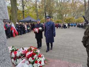 Policjanci w przemarszu, komendanci, poczet flagowy oraz pomnik