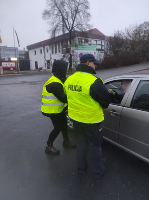 Policjant na drodze zatrzymuje do kontroli, towarzyszy mu członek komisji