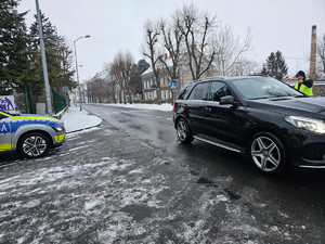 Radiowóz, który zatrzymał do kontroli czarny samochód osobowy