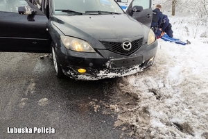 Pojazd na poboczu, obok policjanci zakuwają mezczyzne