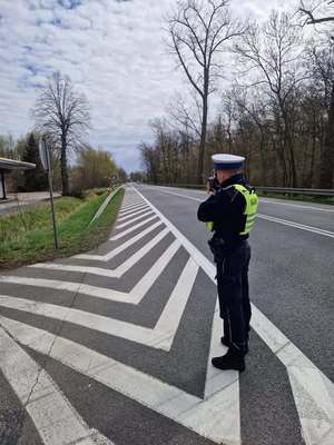 policjant przy drodze kontroluje prędkość