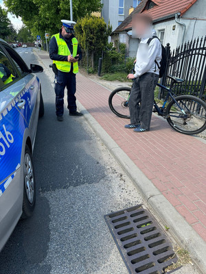 radiowóz i policjanci przy rowerzyście