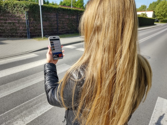 Piesza z telefonem na przejściu dla pieszych