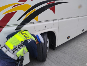 Policjanci sprawdzają stan techniczny świateł, opon, wycieków w autokarze