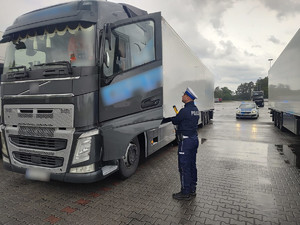 tir, radiowóz i policjant na parkingu