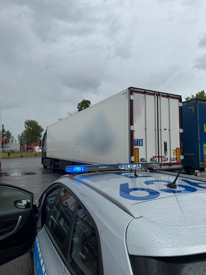 tir, radiowóz i policjant na parkingu