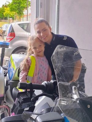 Policjantka z dzieckiem przy motocyklu