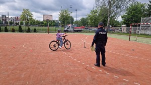 Policjant egzaminuje karte rowerowa