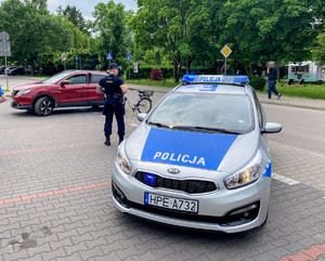Patrol, policjant, radiowóz, pojazd osobowy oraz rower