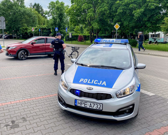 Patrol, policjant, radiowóz, pojazd osobowy oraz rower