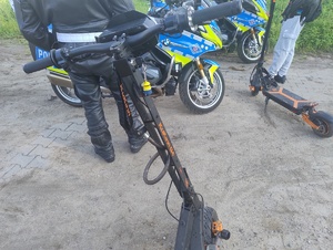 Policjanci, hulajnogi, radiowóz i hulajnoga, widok z góry na hulajnogi