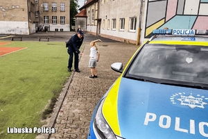 radiowoz, policjant przybija piątke z dzieckiem