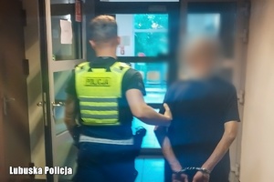 policjant prowadzi zatrzymanego