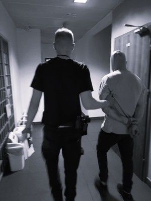policjant prowadzi zatrzymanego