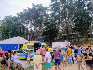 Radiowozy i pojazd z łodzią ratowników oraz tłum zainteresowanych