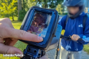 URZADZENIE DO POMIARU PRĘDKOŚCI, W TLE OSOBA W KASKU