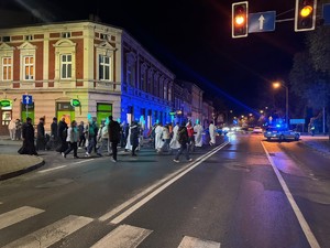 procesja idąca przez miasto wieczorem