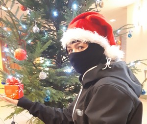 Osoba w masce pod choinką