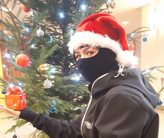 Osoba w masce pod choinką