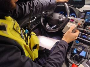 Policjanci kontrolujący trzeźwość na drodze, wyniki na urządzeniach.