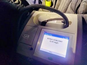 Policjanci kontrolujący trzeźwość na drodze, wyniki na urządzeniach.