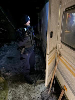 Policjant w nocy kontrolujący miejsca gdzie mogą spać osoby bezdomne zagrożone wychłodzeniem