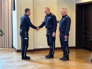 Zdjęcia z odprawy, sala, wyświetlona prezentacja, przemówienia i mundurowi oraz goście na krzesłach