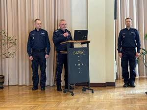 Zdjęcia z odprawy, sala, wyświetlona prezentacja, przemówienia i mundurowi oraz goście na krzesłach