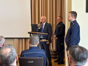 Zdjęcia z odprawy, sala, wyświetlona prezentacja, przemówienia i mundurowi oraz goście na krzesłach