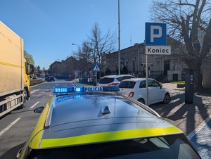 radiowóz przy pojazdach zaparkowanych przy przejściu dla pieszych