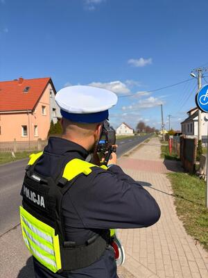 Policjant mierzy prędkość pojazdu, zatrzymuje kierującego
