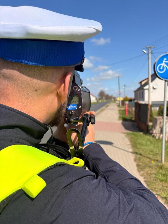 Policjant mierzy prędkość pojazdu, zatrzymuje kierującego